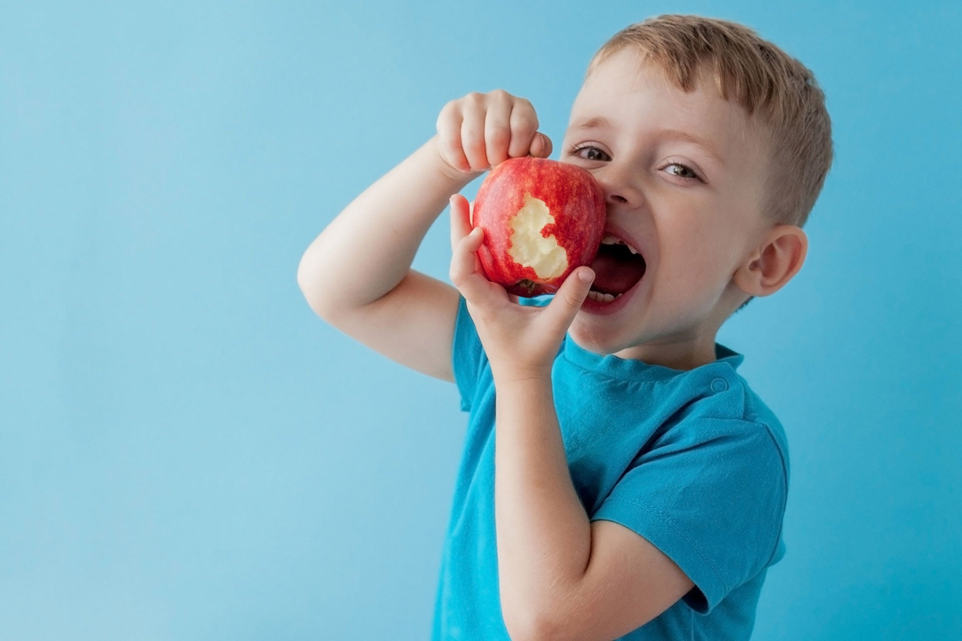boy eating red apple